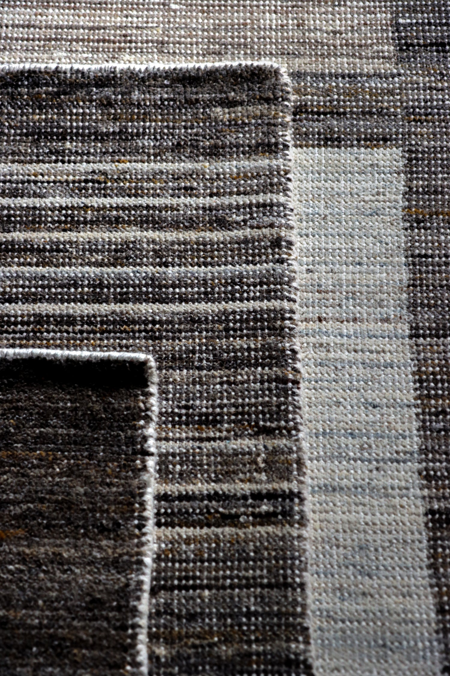 Three 100% Indian Wool Hand-Knotted Savannah Collection Area rugs from Bashian, stacked on top of one another.